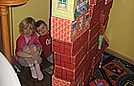 Savannah and Ricky built a tall castle and are pretending to live inside it