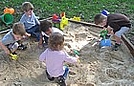 Pretending to be paleontologists who are digging for dinosaurs in the sand