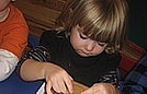 Alaina is focusing as she is placing one piece of gingerbread on the engine